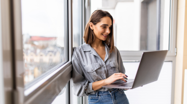 Une collaboratrice debout qui tient son pc